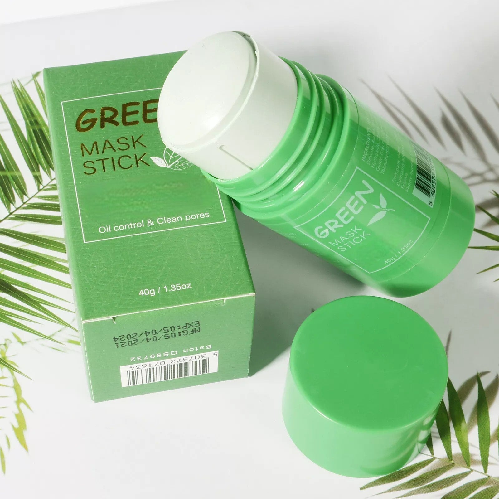 Green mask stick with packaging on a white background